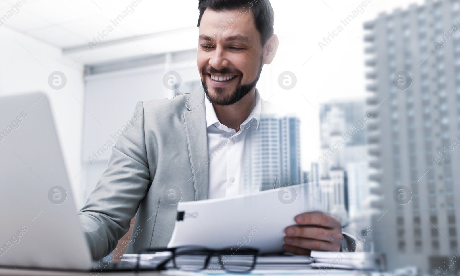 Image of Double exposure of architect working with laptop at table and cityscape