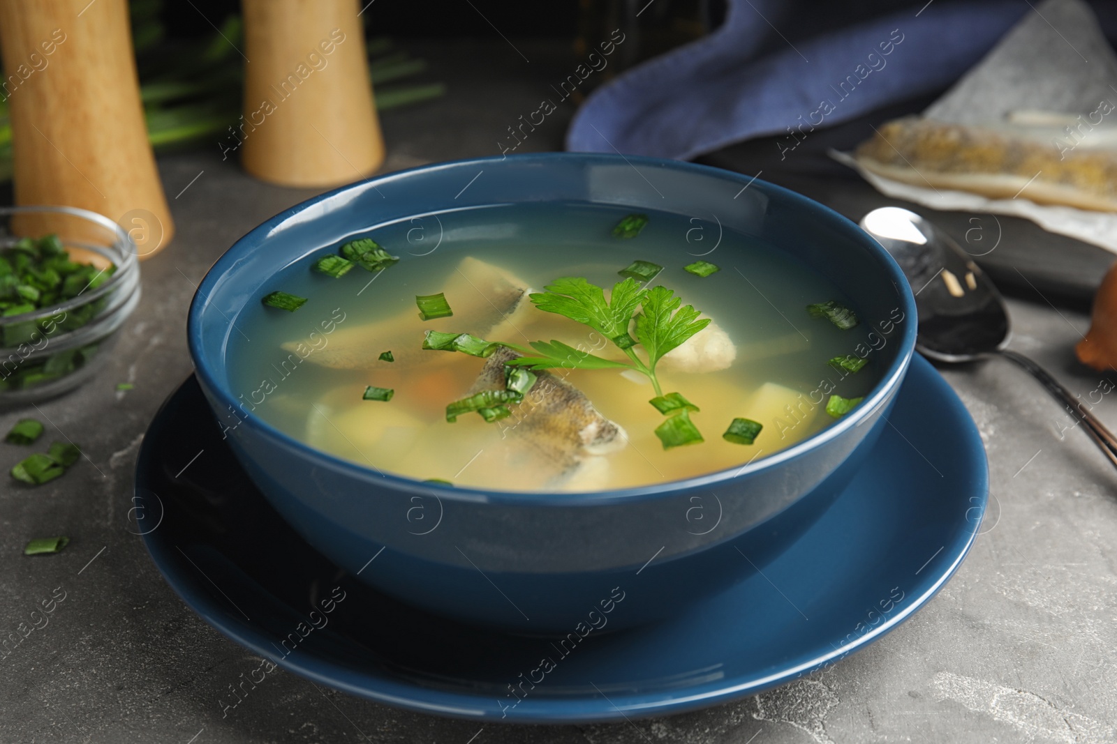 Photo of Delicious fish soup served on grey table, closeup