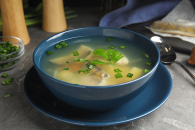 Photo of Delicious fish soup served on grey table, closeup