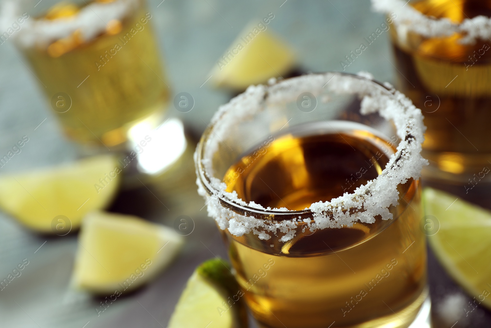 Photo of Mexican Tequila shot with salt on table, closeup