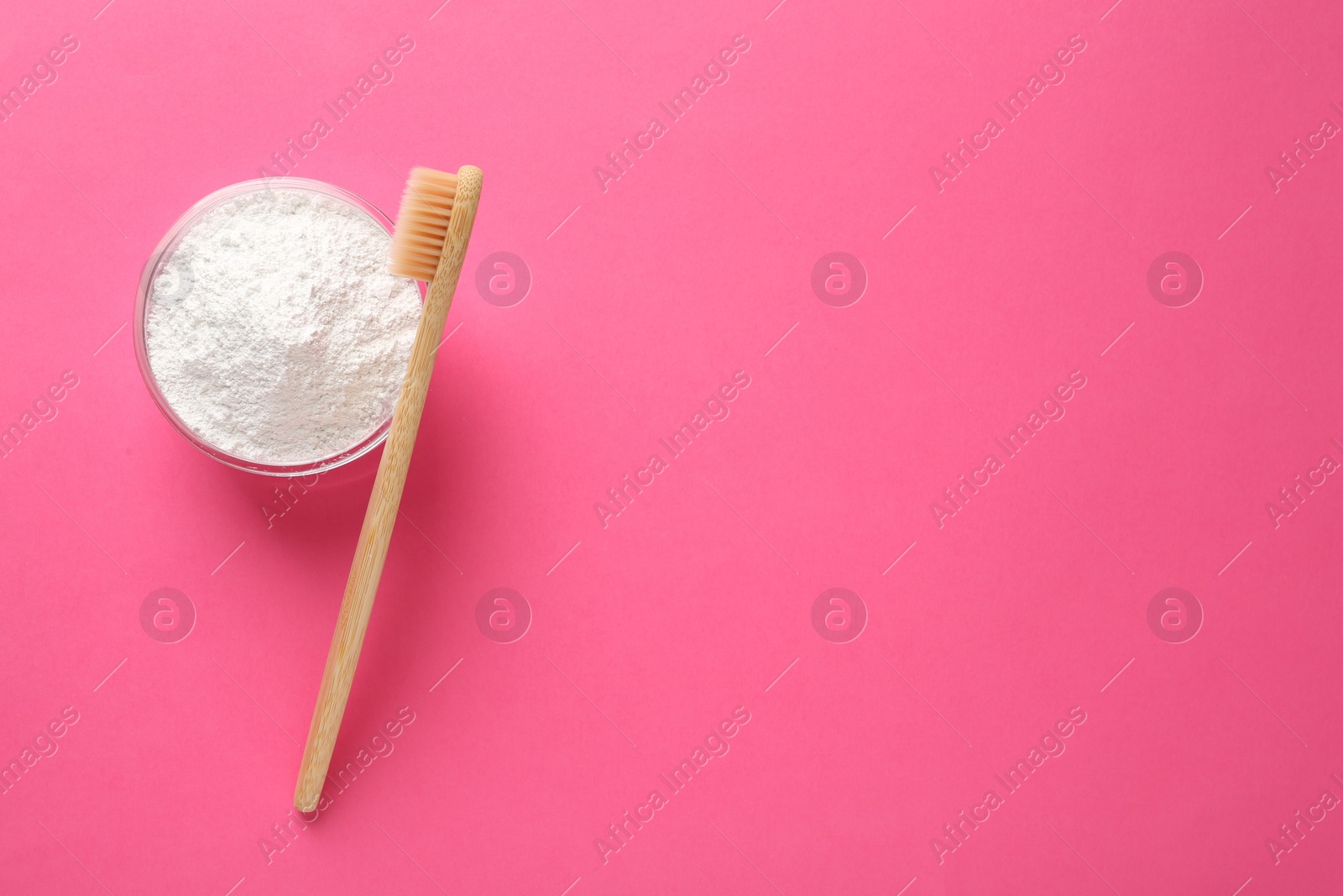 Photo of Bowl of tooth powder and brush on pink background, flat lay. Space for text
