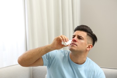 Ill man using nasal spray at home