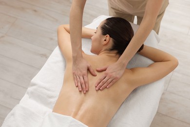 Photo of Woman receiving back massage on couch in spa salon, above view