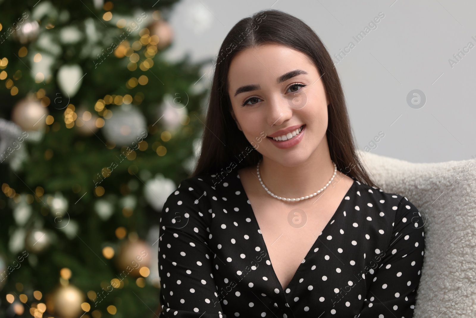 Photo of Portrait of happy woman near Christmas tree indoors