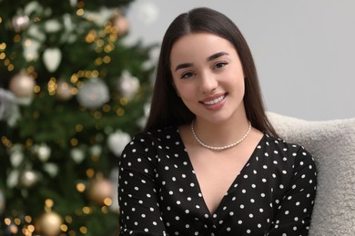 Photo of Portrait of happy woman near Christmas tree indoors