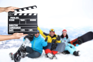 Image of Assistant  holding clapperboard and people at mountain resort, closeup. Cinema production 