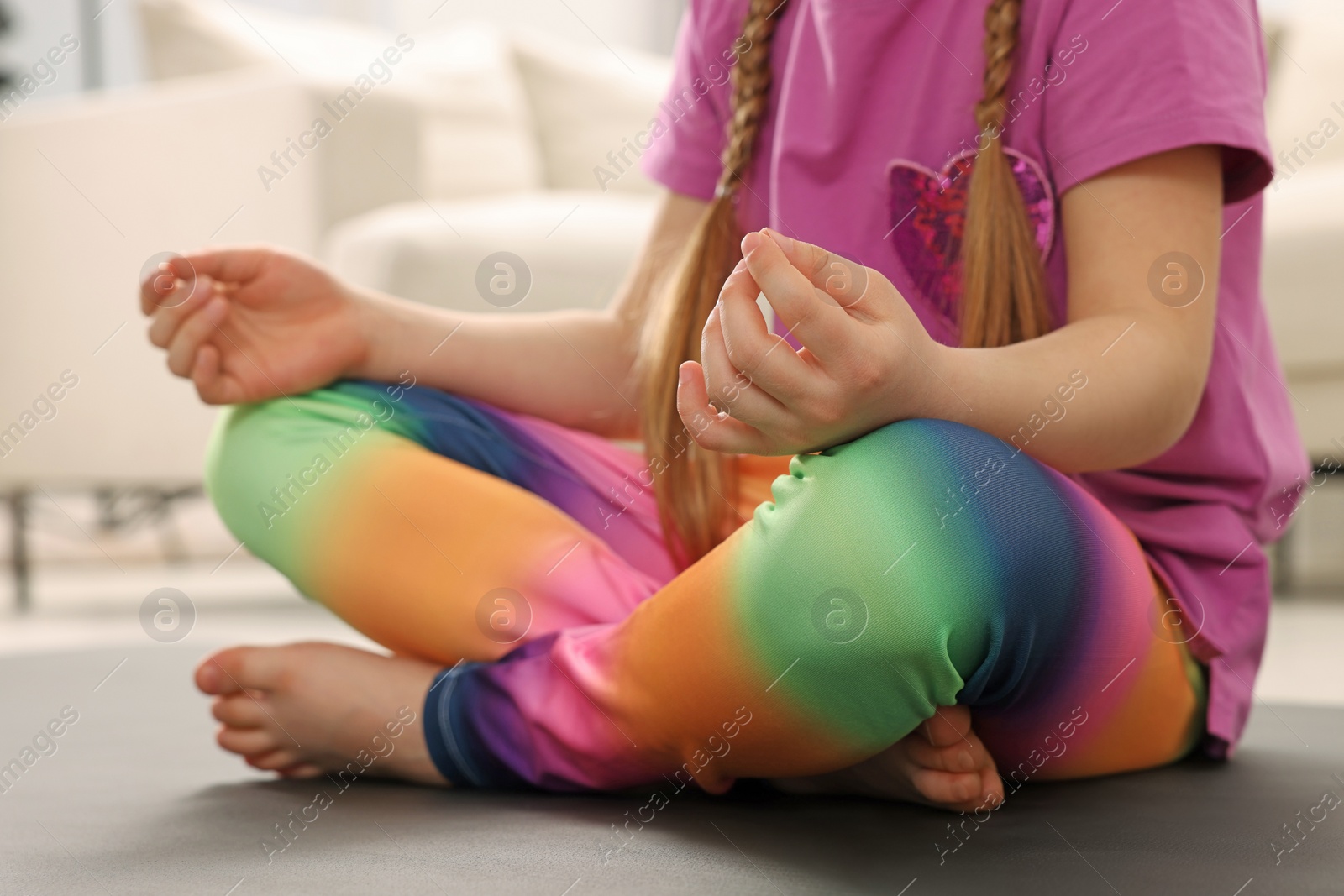 Photo of Little girl meditating at home, closeup. Harmony and zen