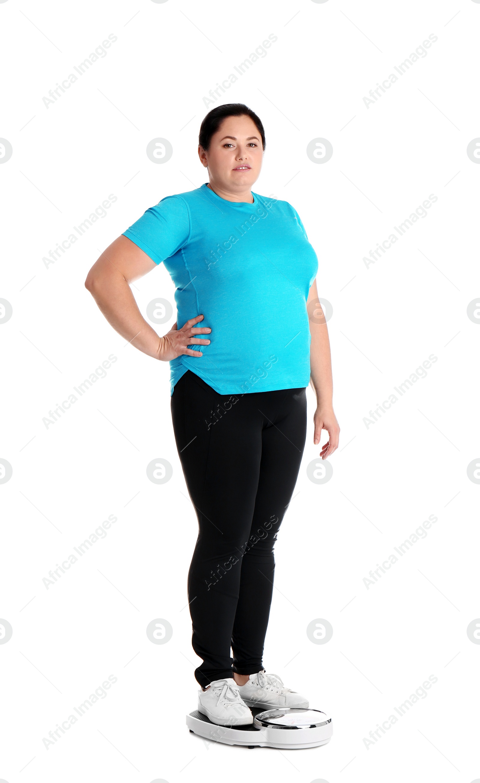 Photo of Overweight woman in sportswear using scales on white background