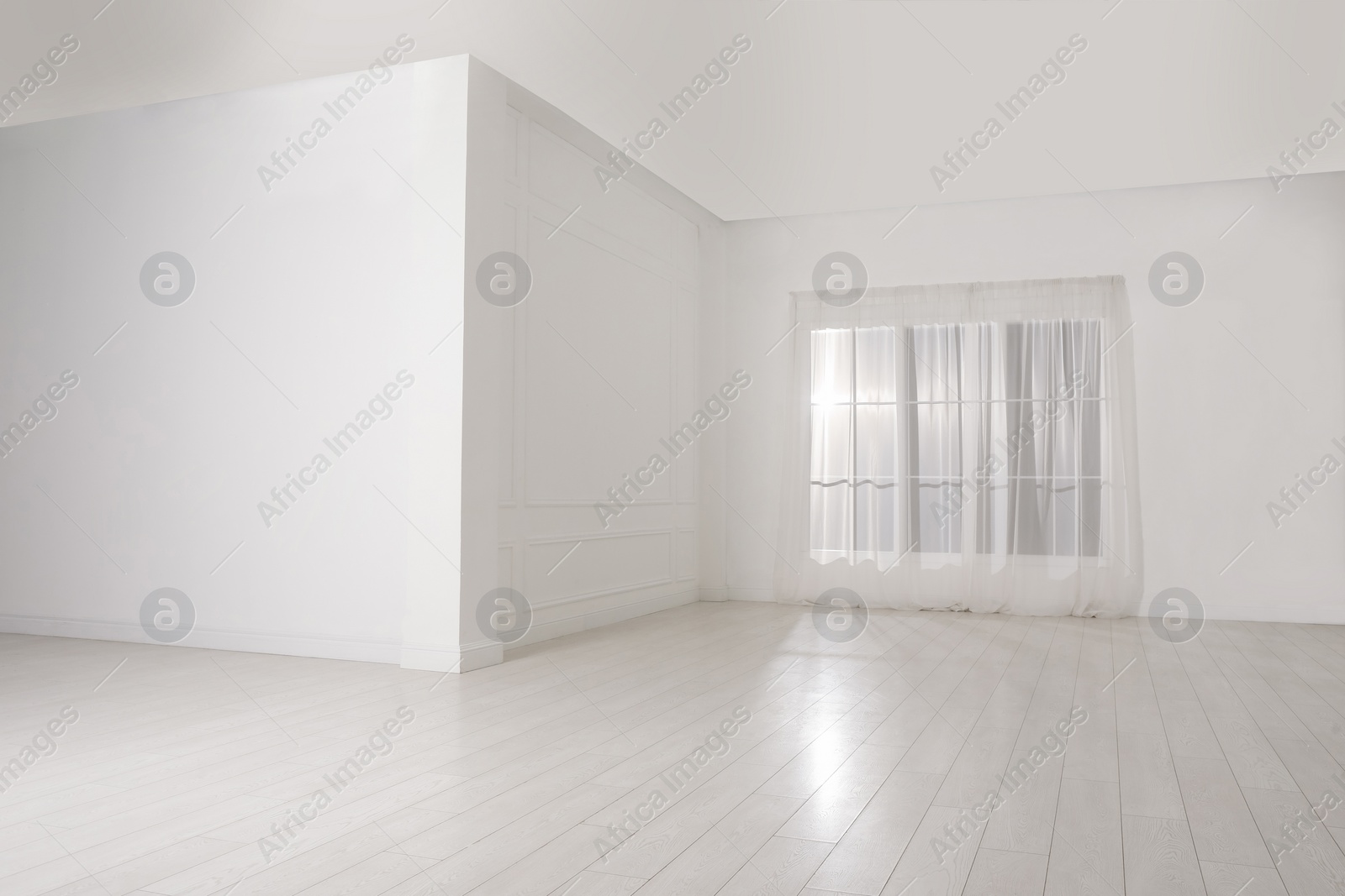 Photo of Empty room with white walls and large window