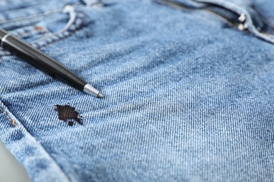 Pen and stain of black ink on jeans, closeup. Space for text