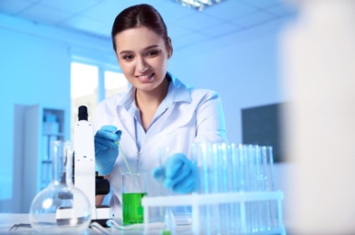 Photo of Female scientist working with sample in modern chemistry laboratory