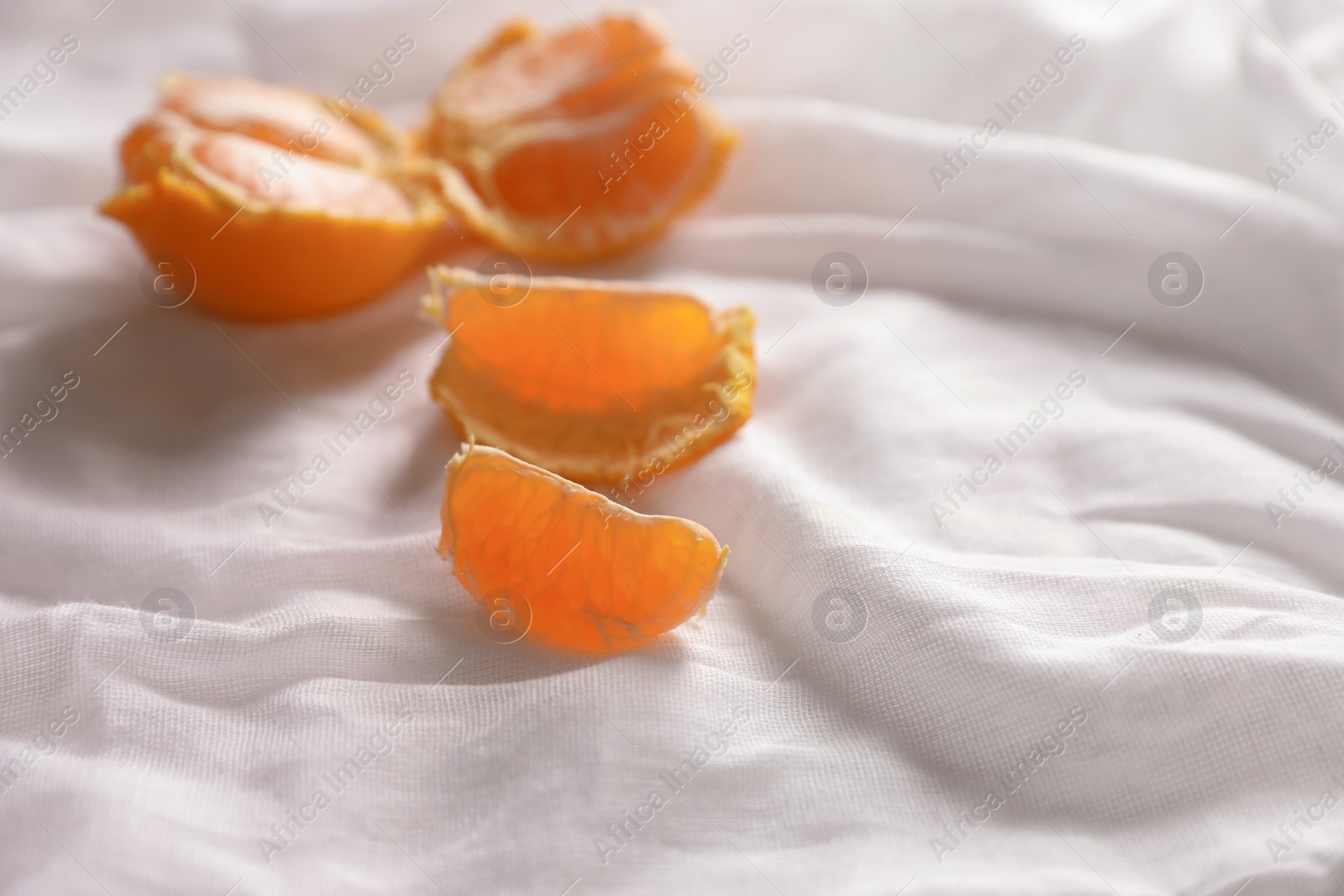 Photo of Fresh ripe tangerines on white cloth. Space for text