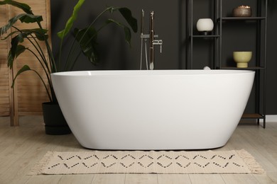 Photo of Spa day. Stylish bathroom with ceramic tub and houseplant