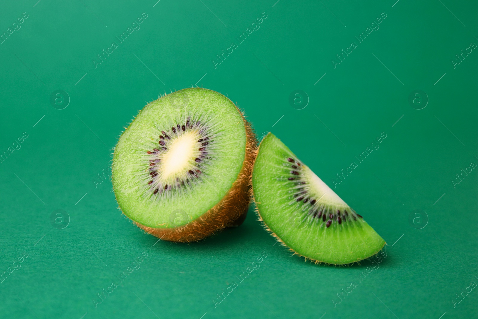 Photo of Cut fresh ripe kiwi on green background, closeup
