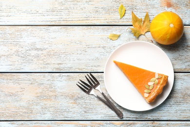Photo of Flat lay composition with fresh delicious homemade pumpkin pie on wooden background. Space for text