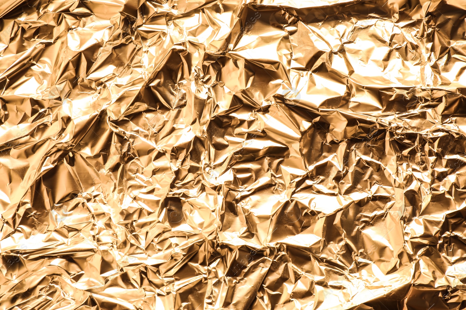 Photo of Crumpled gold foil as background, top view