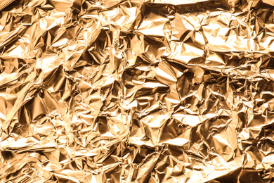 Crumpled gold foil as background, top view