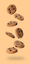 Image of Delicious chocolate chip cookies falling on dark beige background