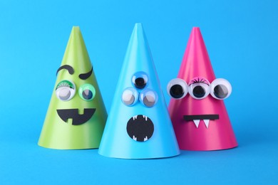 Photo of Spooky paper monsters on light blue background. Halloween decoration