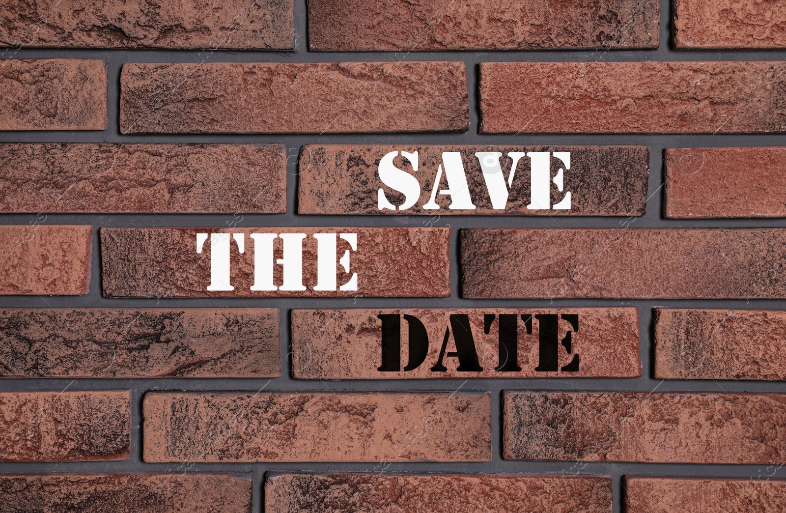 Image of Phrase SAVE THE DATE on brick wall