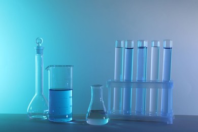 Laboratory analysis. Different glassware on table against color background