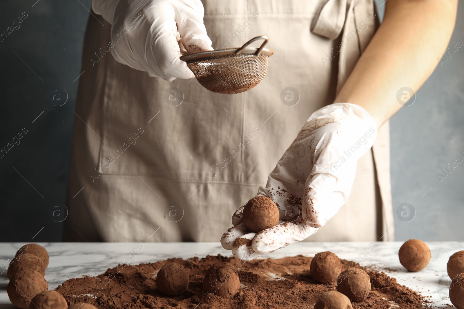 Photo of Woman preparing tasty chocolate truffles at table, closeup