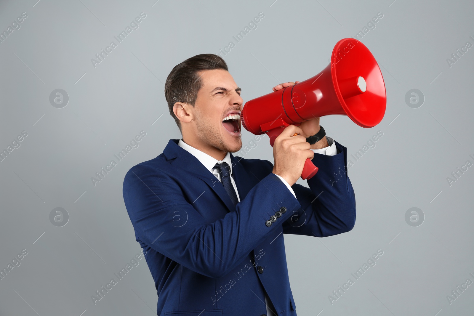 Photo of Handsome man with megaphone on grey background