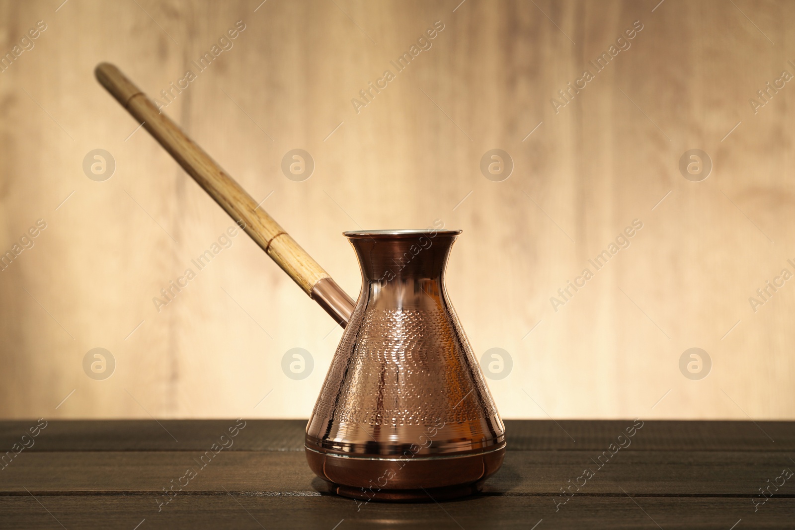 Photo of Beautiful copper turkish coffee pot on wooden table