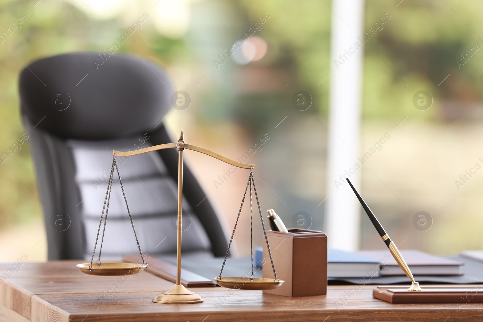 Photo of Table with scales of justice in lawyer's office