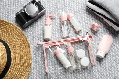 Flat lay composition with cosmetic travel kit on sofa