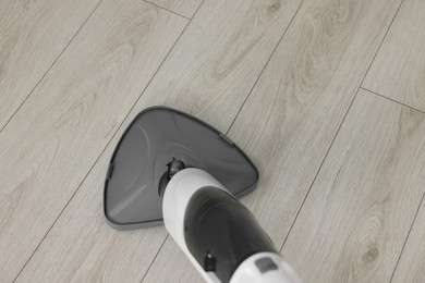 Photo of Cleaning floor with steam mop at home, above view