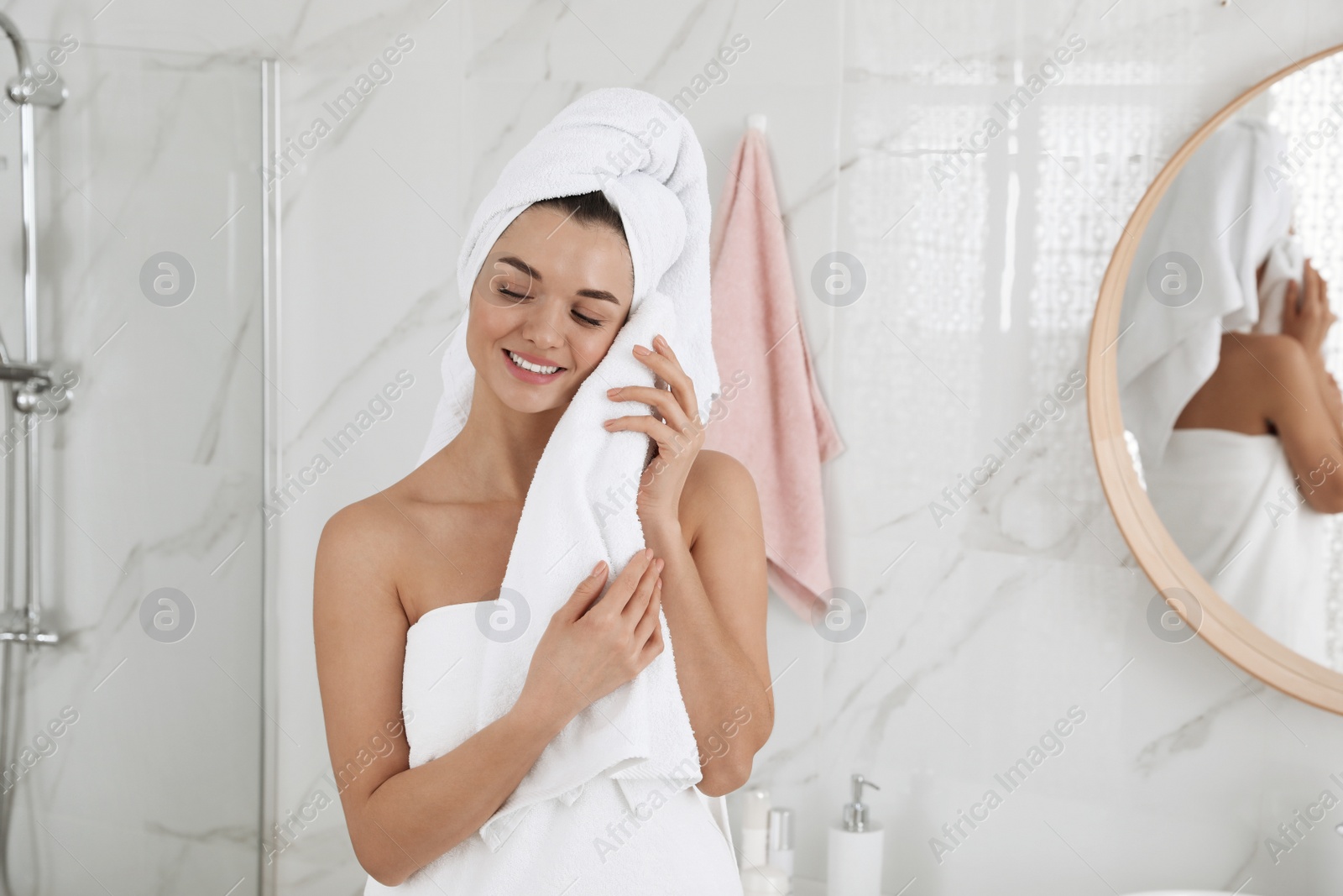 Photo of Beautiful young woman with hair wrapped in towel indoors