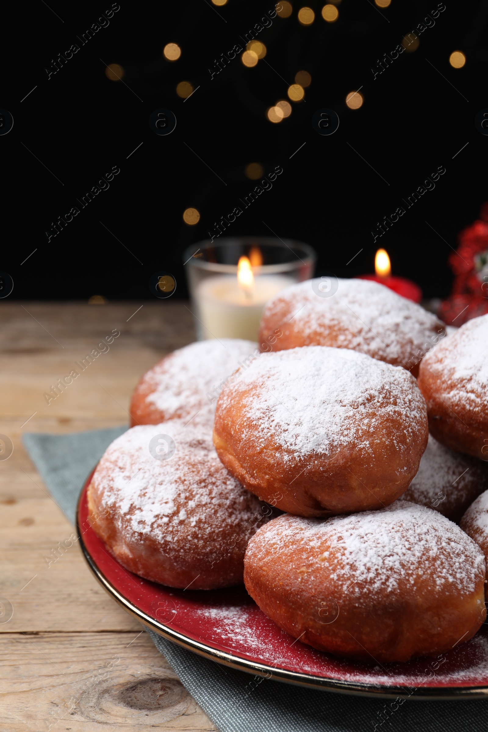 Photo of Delicious sweet buns on table against black background with blurred lights