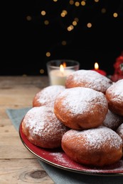 Photo of Delicious sweet buns on table against black background with blurred lights