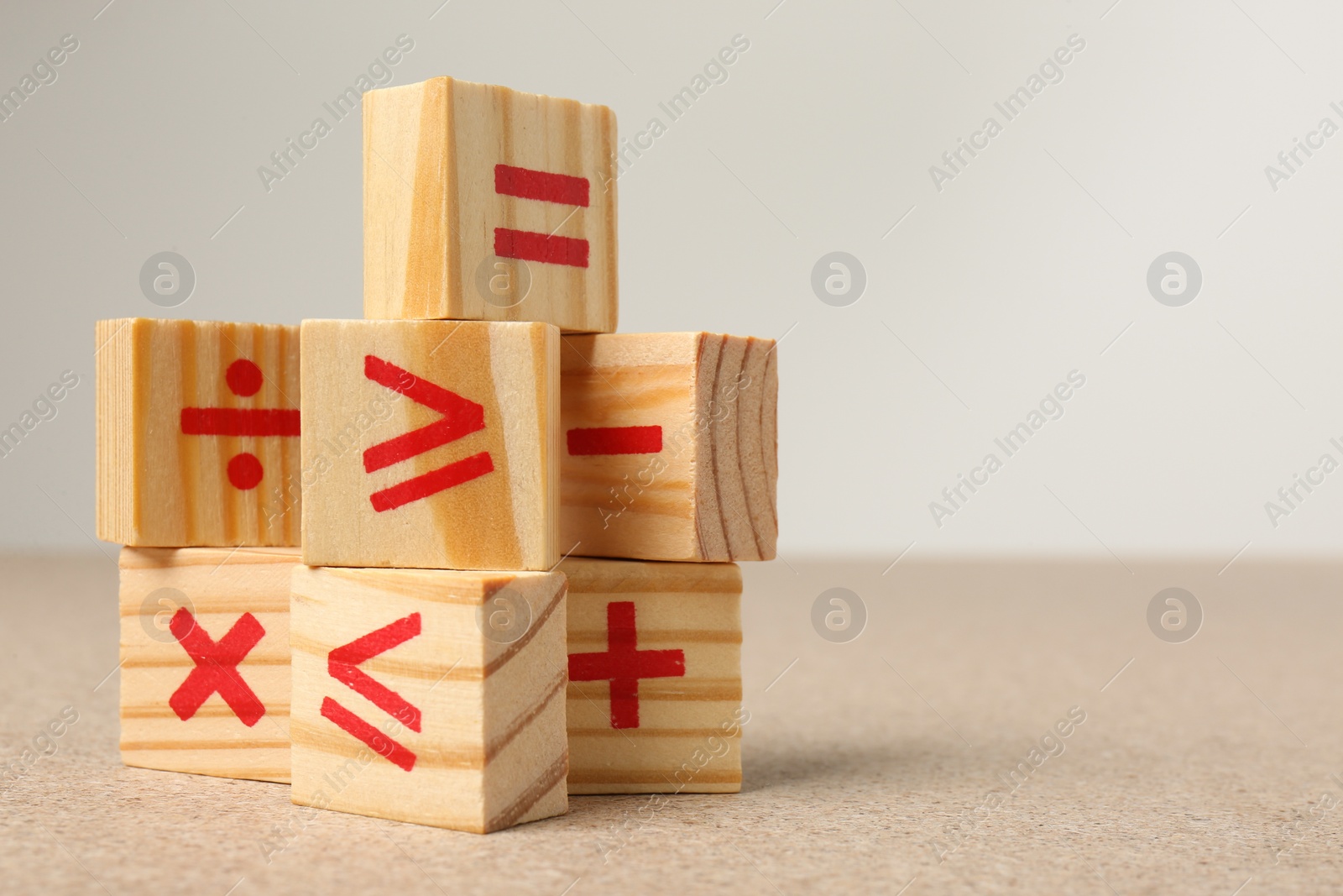 Photo of Wooden cubes with mathematical symbols on table against light background. Space for text