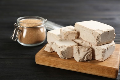 Pieces of compressed yeast on black wooden table