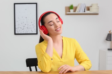 Happy woman in headphones enjoying music at home