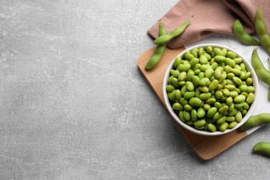 Photo of Organic edamame beans on light grey table, flat lay. Space for text