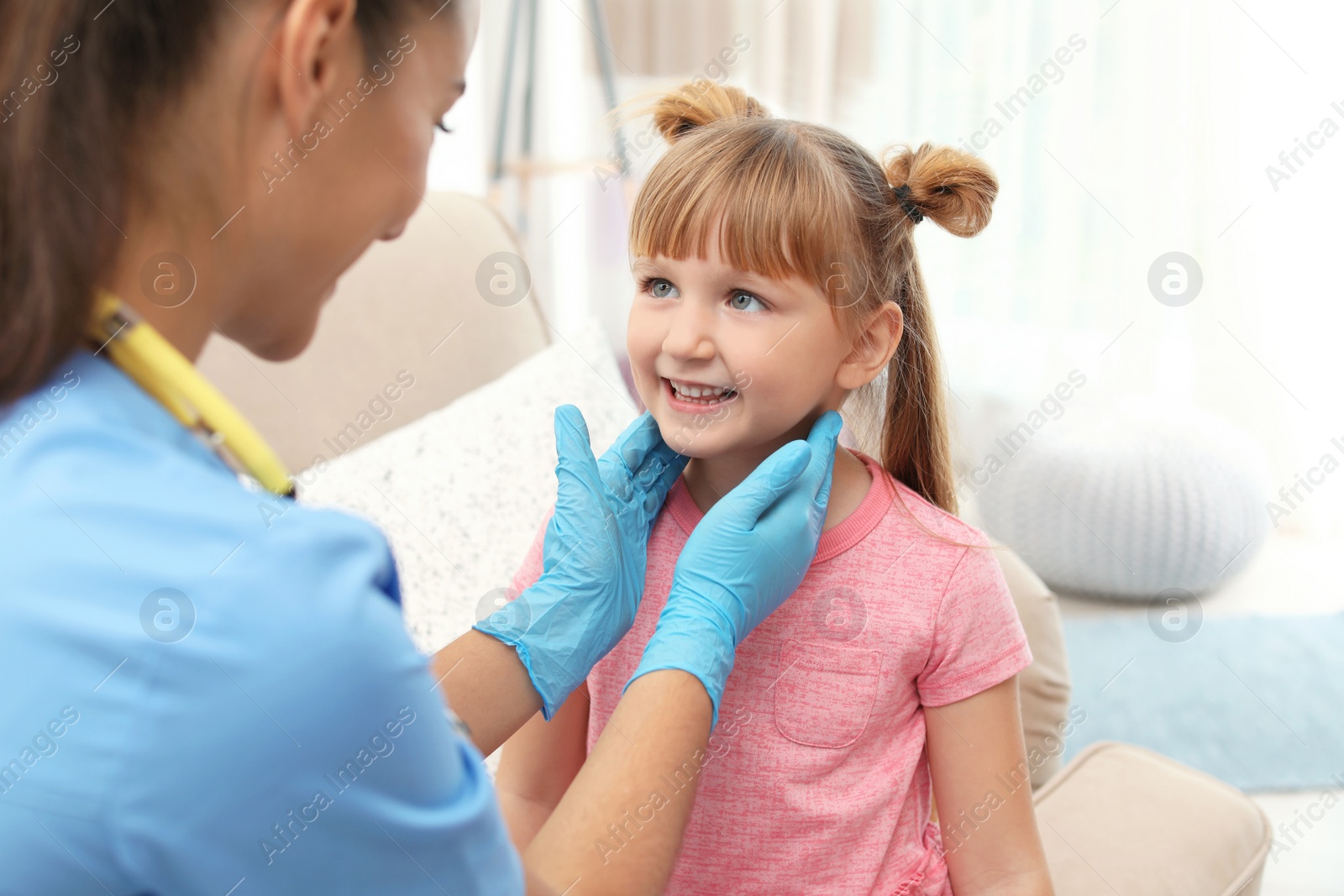 Photo of Children's doctor visiting little girl at home