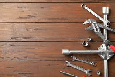 Photo of Auto mechanic's tools on wooden background, flat lay. Space for text