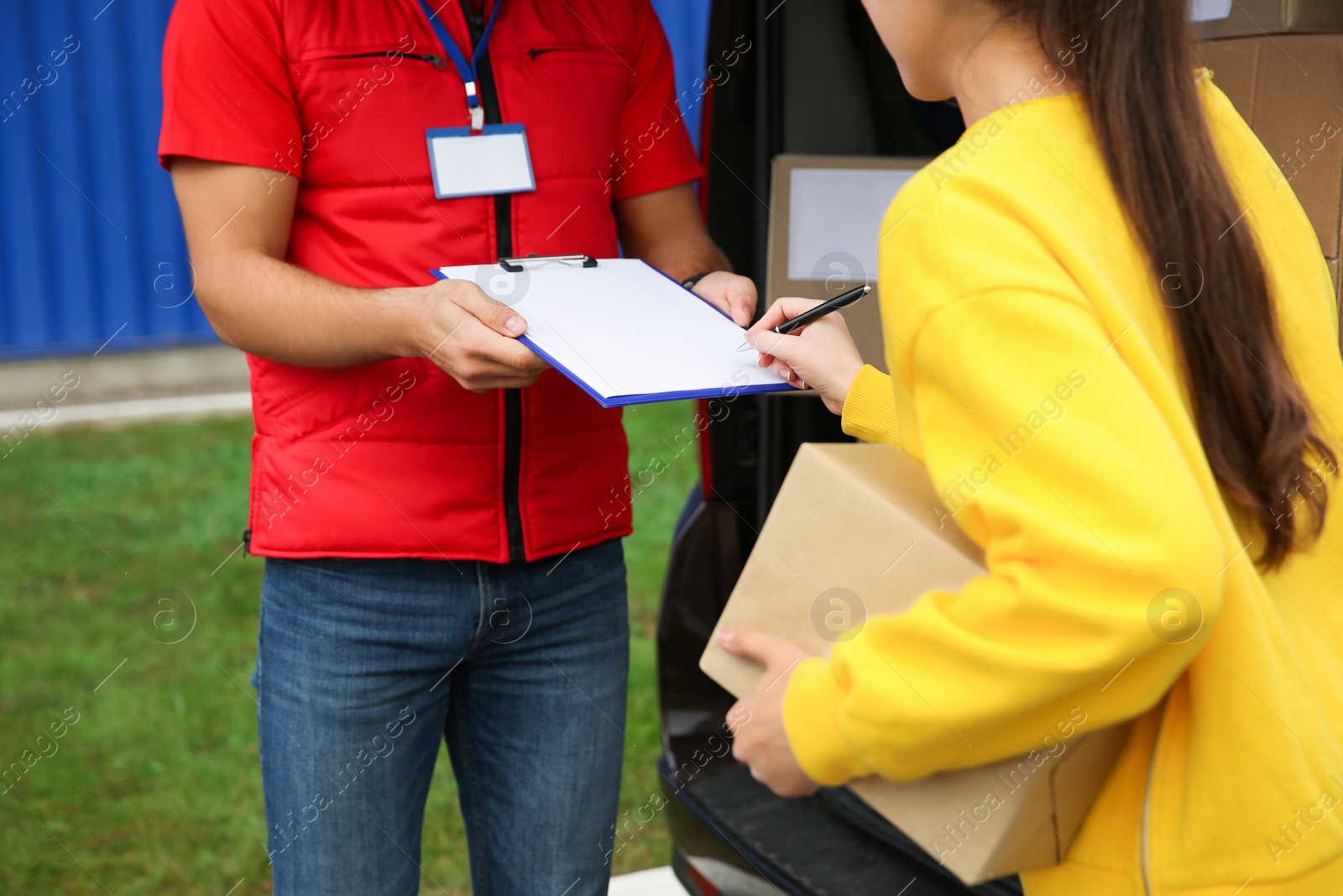 Photo of Courier receiving receipt signature from customer outdoors, closeup