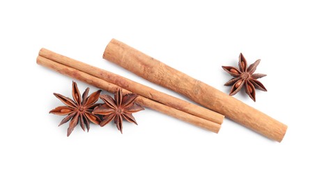 Photo of Aromatic cinnamon sticks and anise stars isolated on white, top view