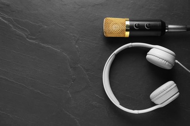 Photo of Microphone and headphones on grey textured background, flat lay with space for text. Sound recording and reinforcement