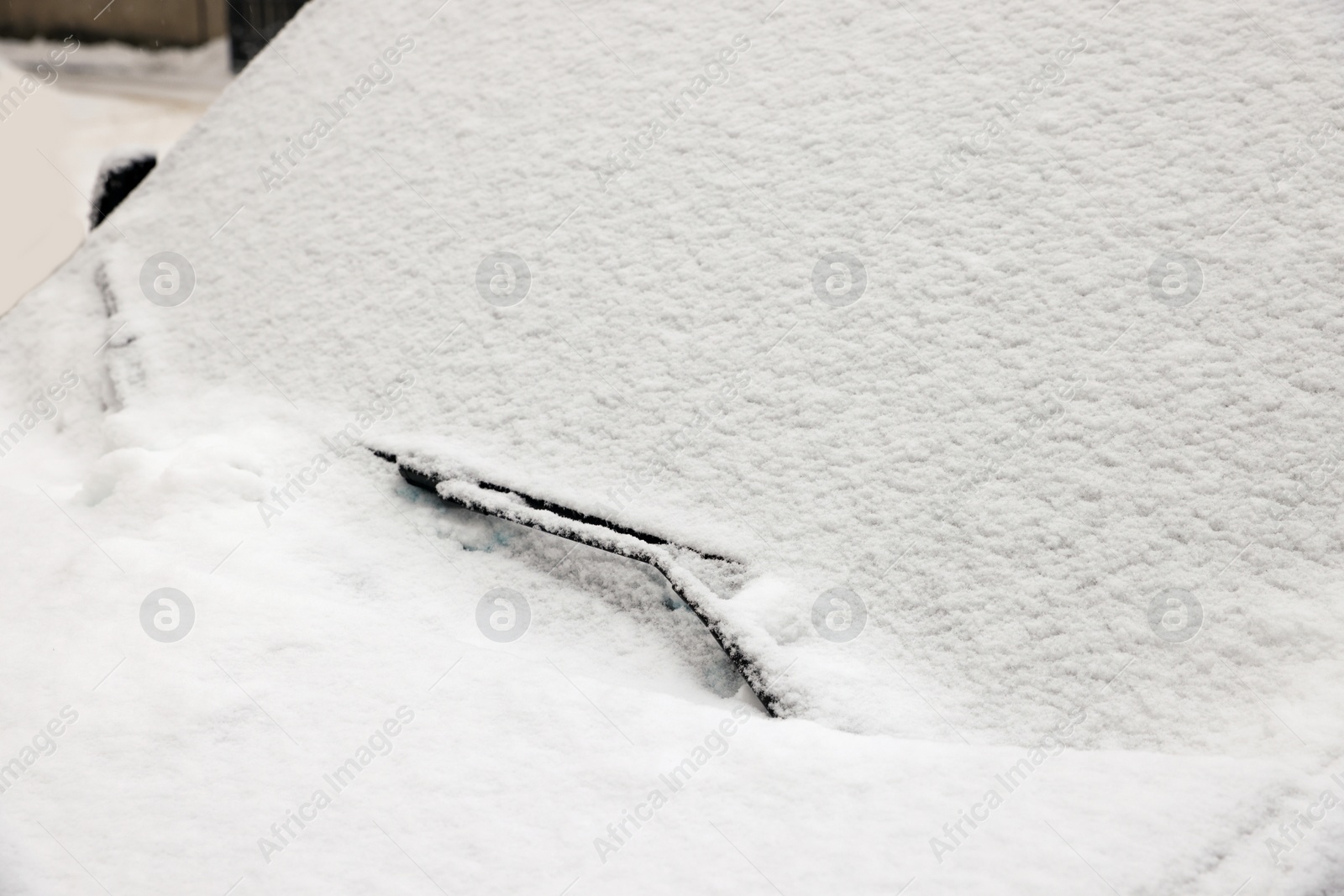 Photo of Car with windscreen wipers covered with snow outdoors on winter day