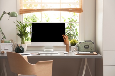 Photo of Light work place with computer near window at home. Interior design