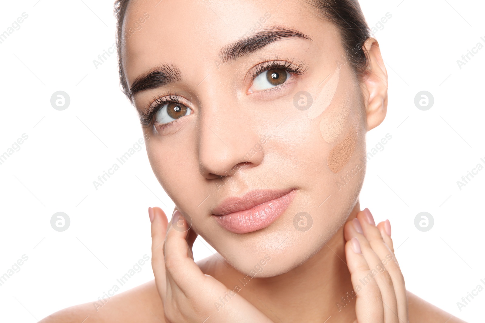 Photo of Young woman with different shades of skin foundation on her face against white background