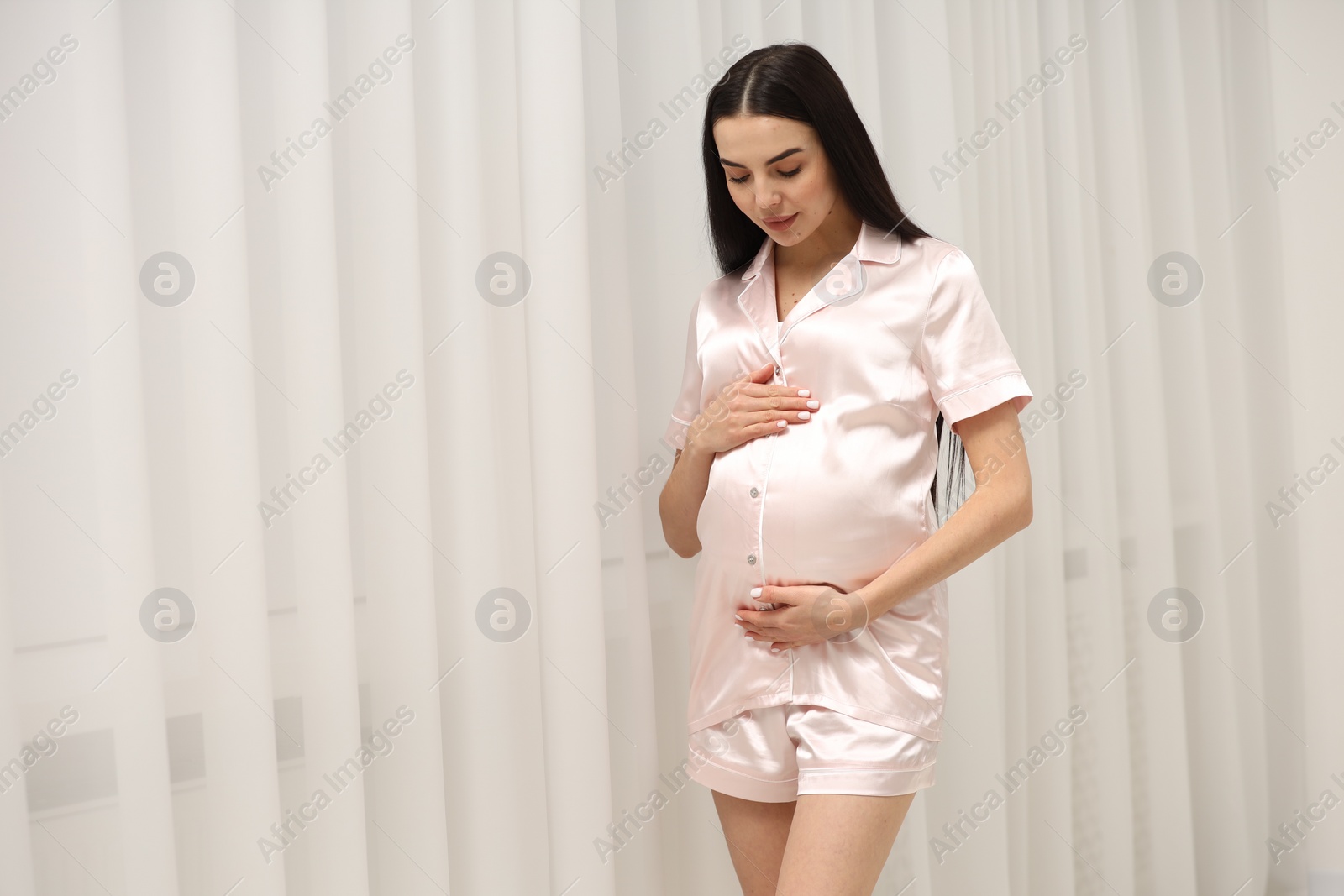 Photo of Pregnant young woman indoors, space for text