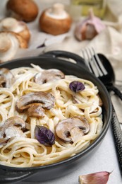 Photo of Delicious pasta with mushrooms on grey table, closeup