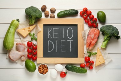 Small chalkboard with words Keto Diet and fresh products on white wooden table, flat lay