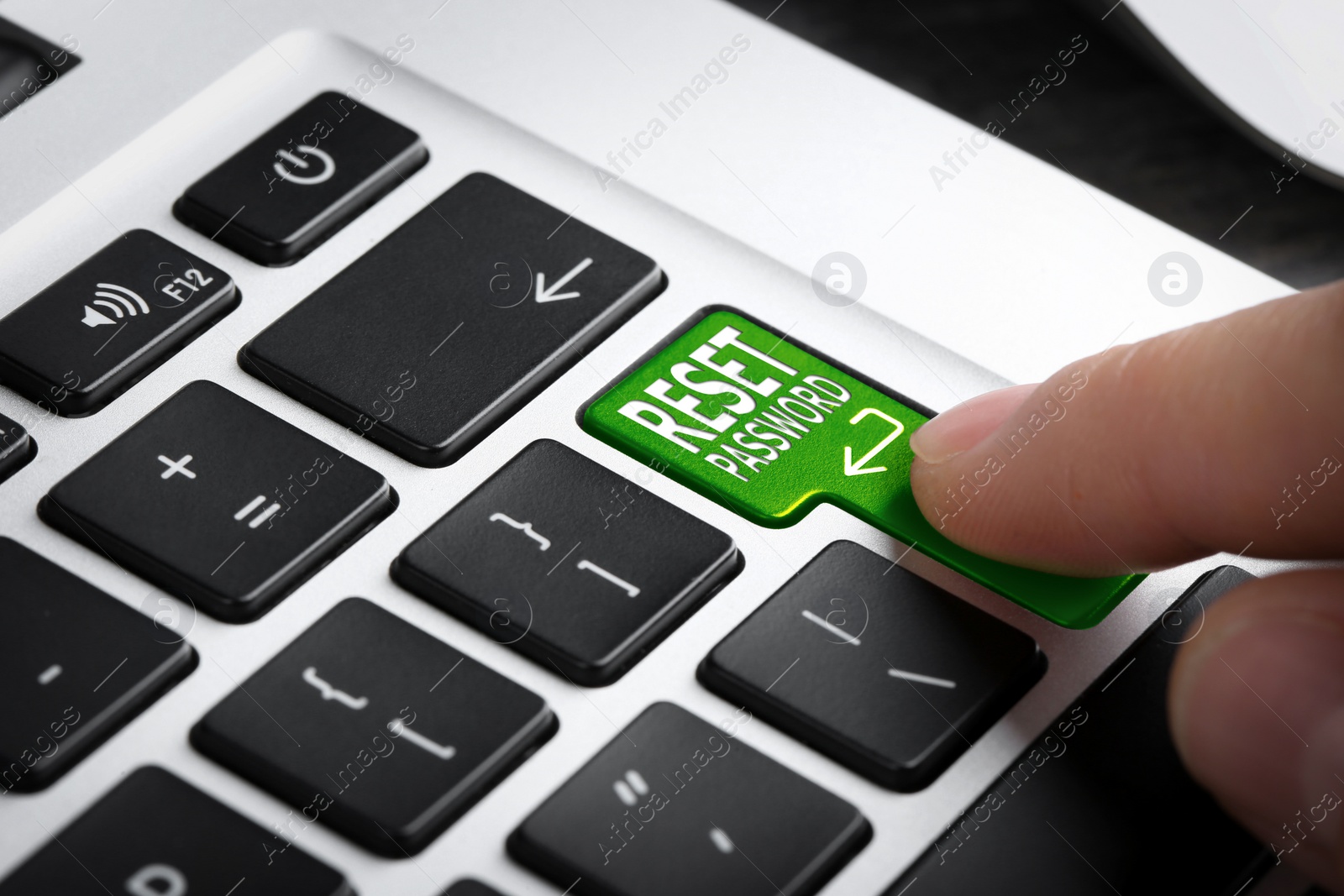 Image of Woman pressing button RESET PASSWORD on laptop keyboard, closeup